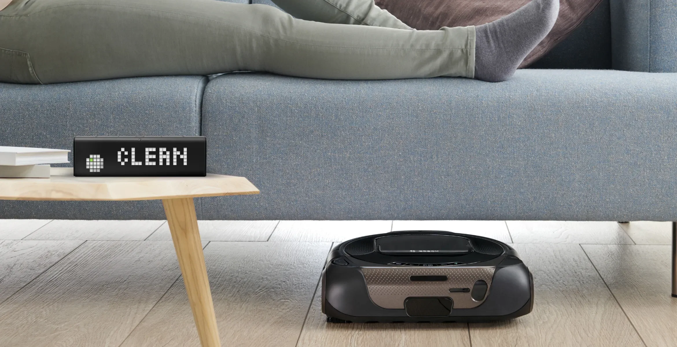 LaMetric Time stands in the living room in front of Bosch robot cleaner